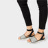 Black sandals with glittery sole worn with black pants on a white background