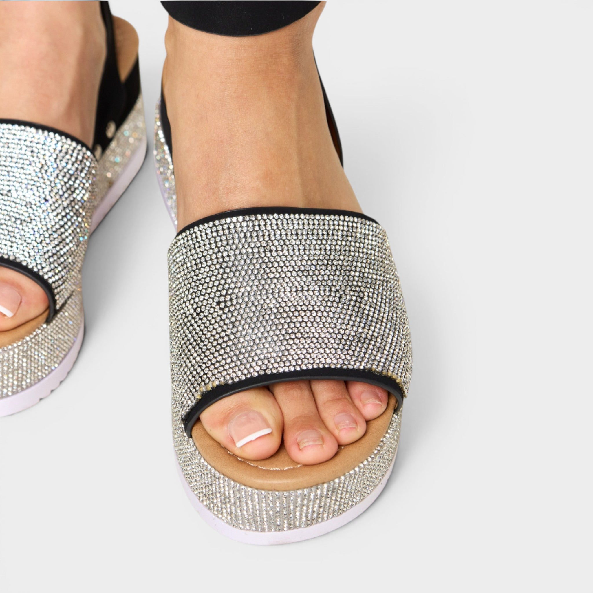 Silver embellished sandals on a white background