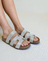 Silver embellished sandals on a light background