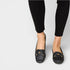 Black loafers worn with black pants on a white background