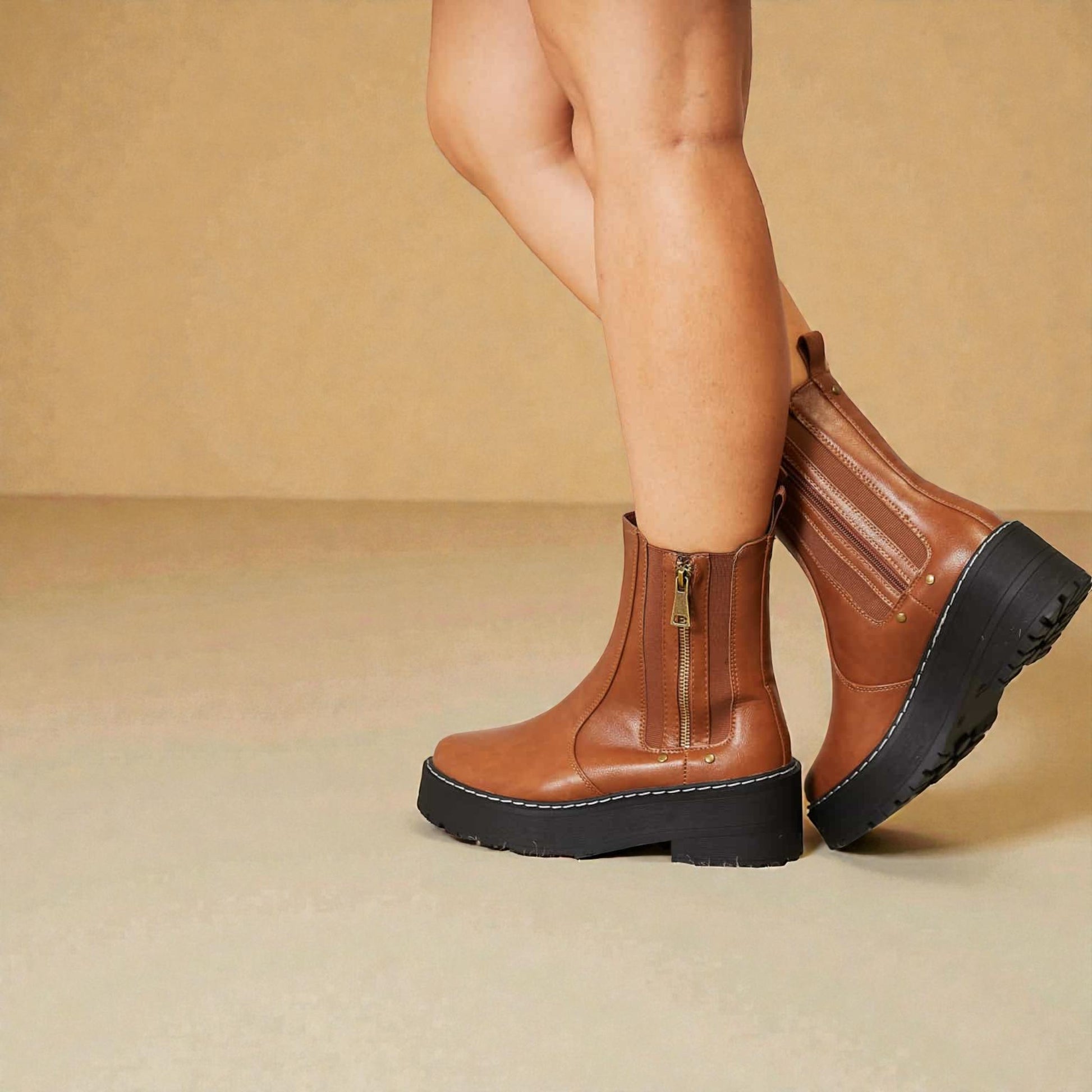 Brown platform boots with zippers on a beige background