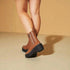 Brown platform boots worn by a person on a beige background