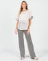 Woman wearing a textured top and striped pants on a white background