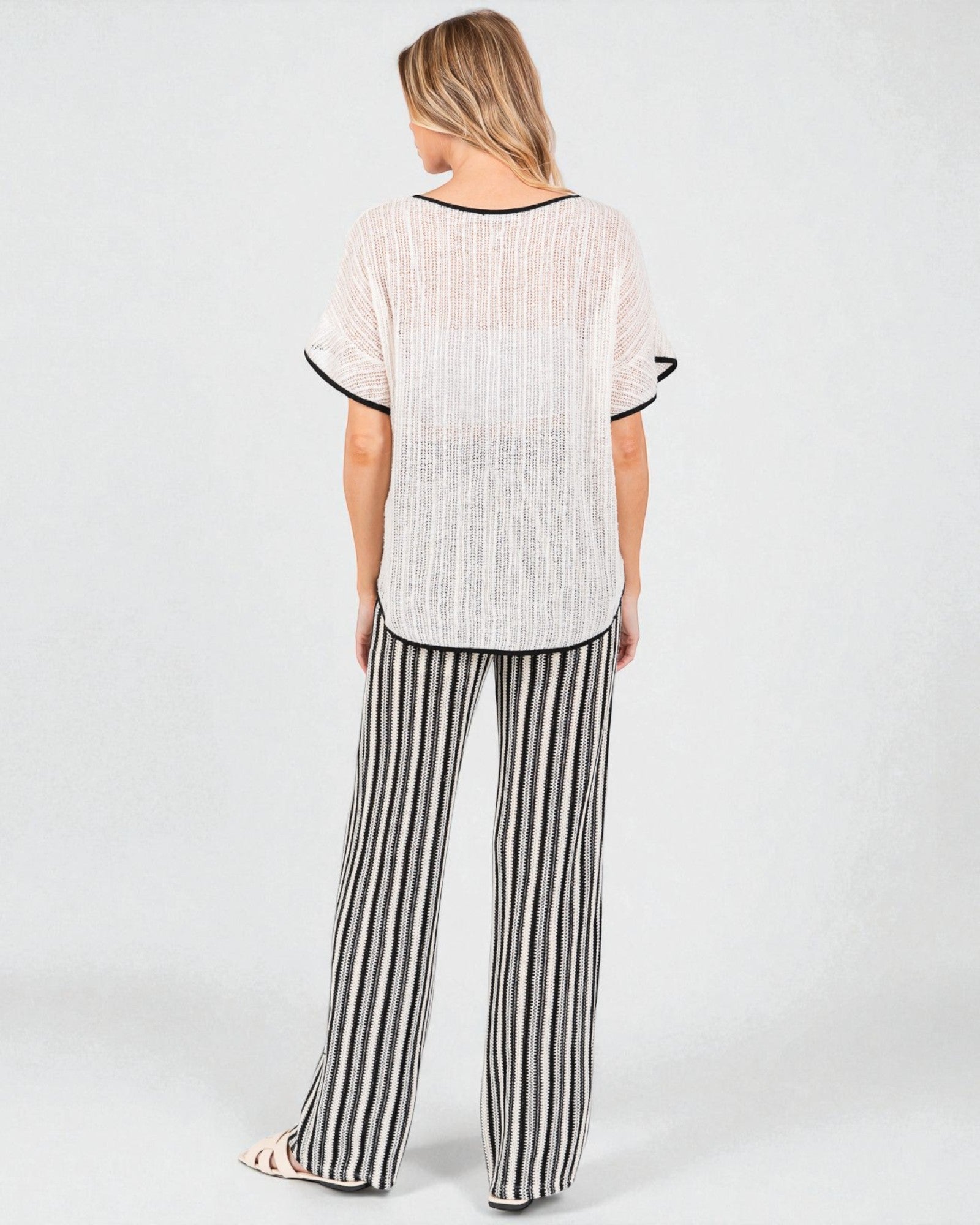 Woman wearing a striped outfit with a plain background