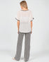 Woman wearing a striped outfit with a plain background
