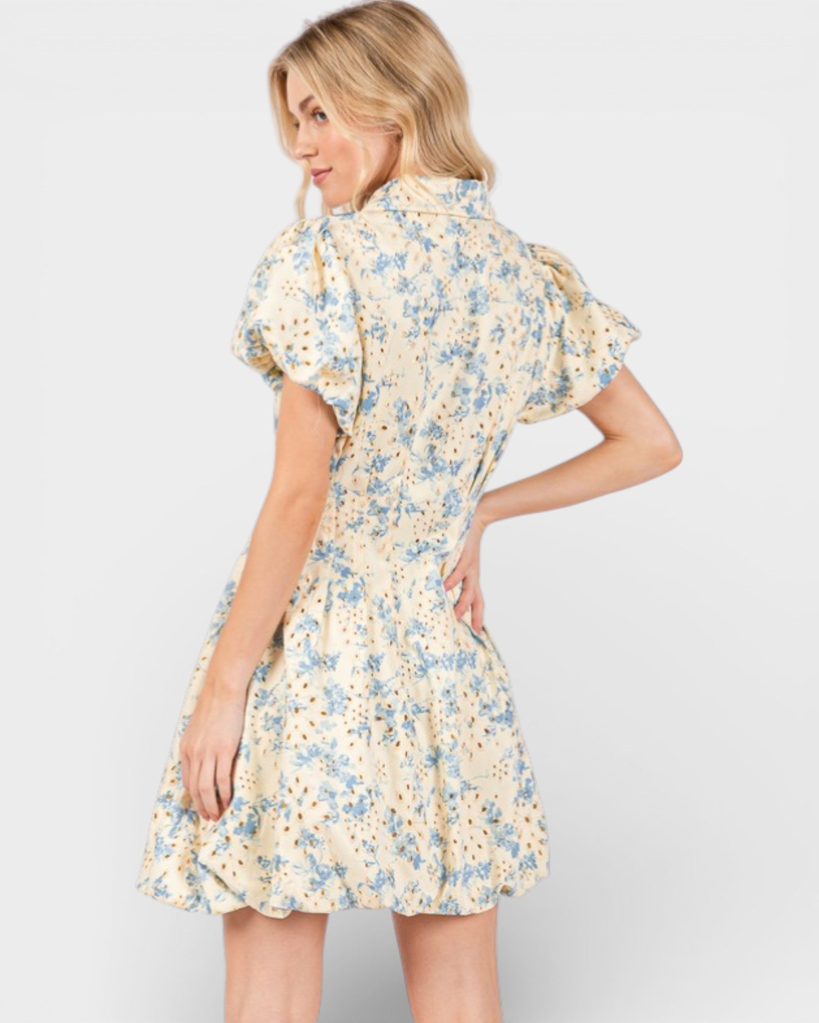 Woman wearing a floral dress on a plain background