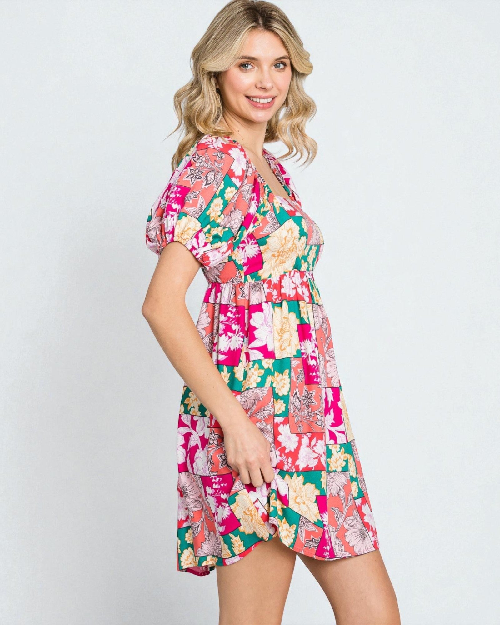 Woman wearing a colorful floral dress on a white background