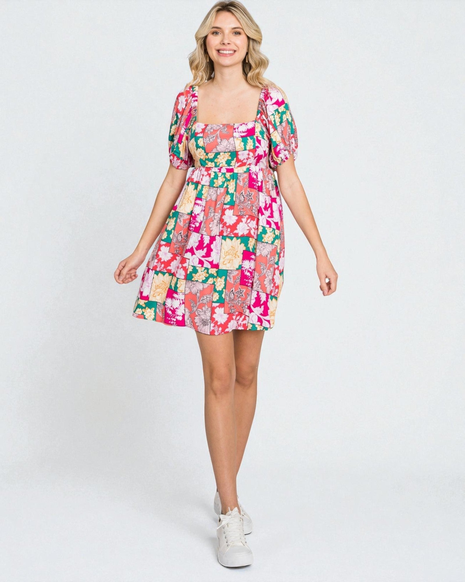 Woman wearing a colorful floral dress on a white background