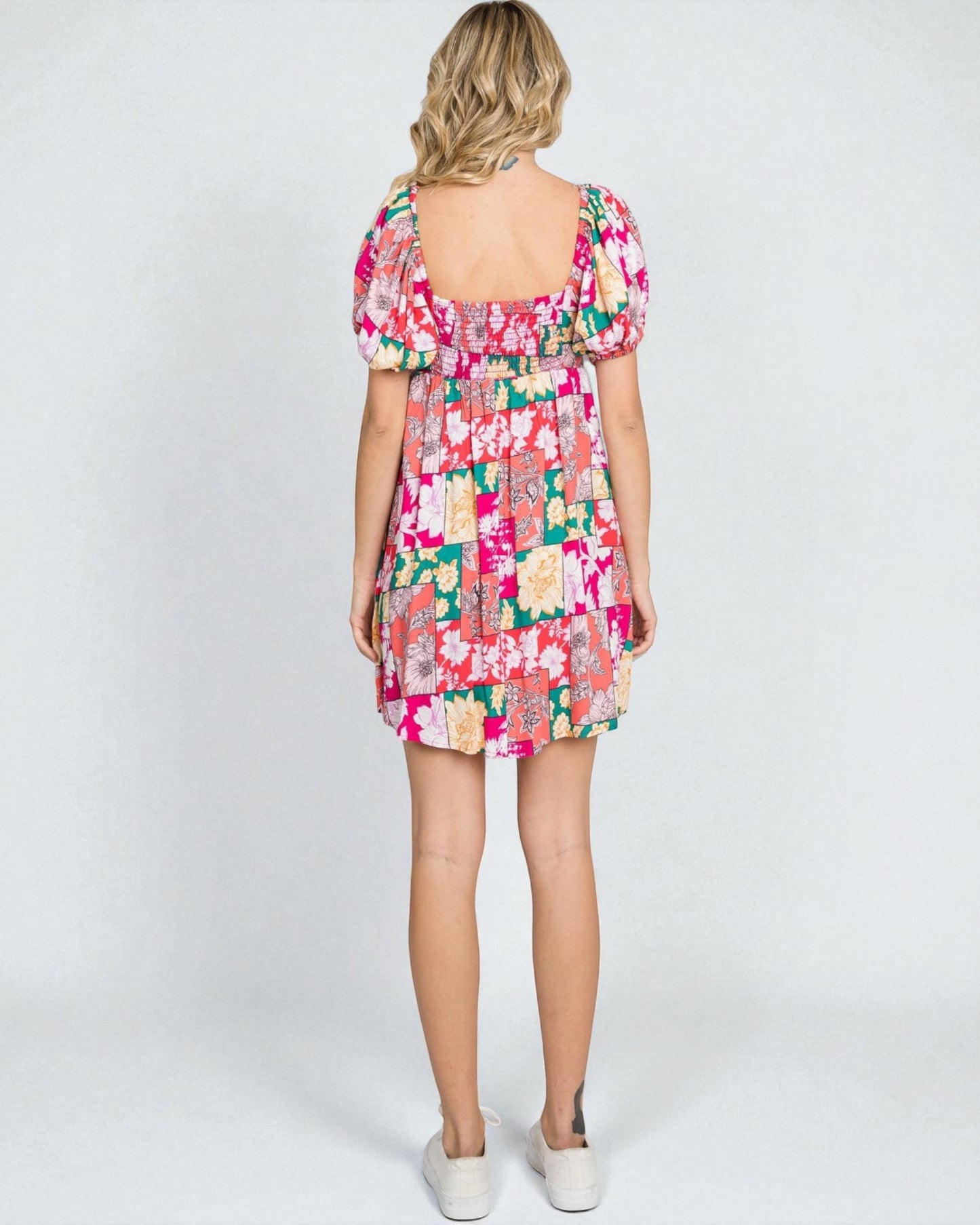 Woman wearing a colorful floral dress on a white background