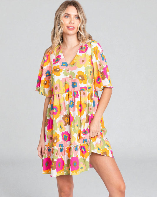 Woman wearing a colorful floral dress on a gray background