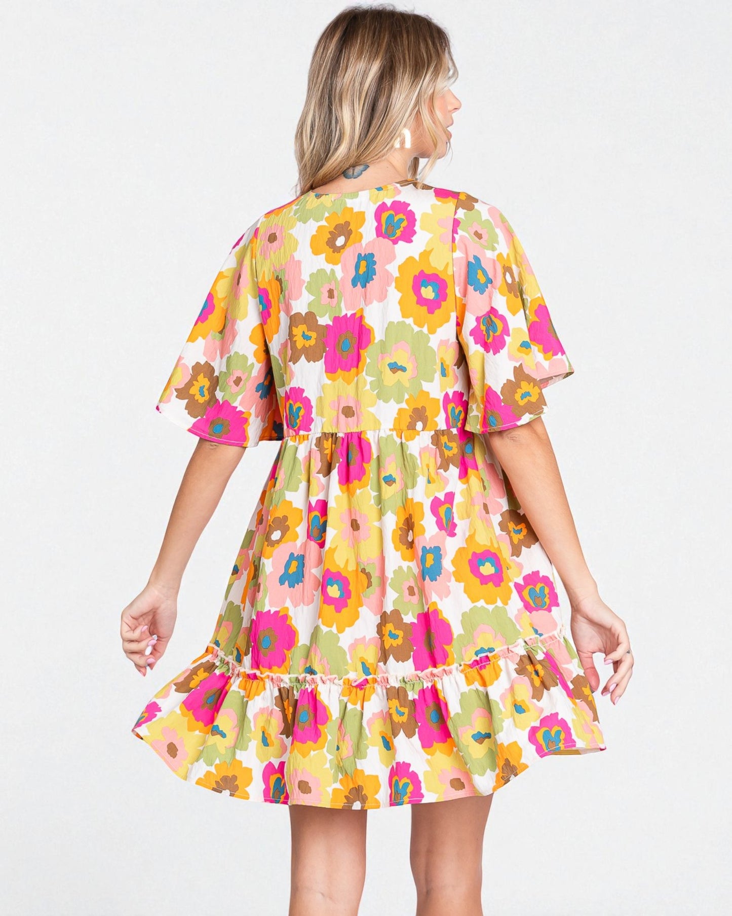 Woman wearing a colorful floral dress on a white background