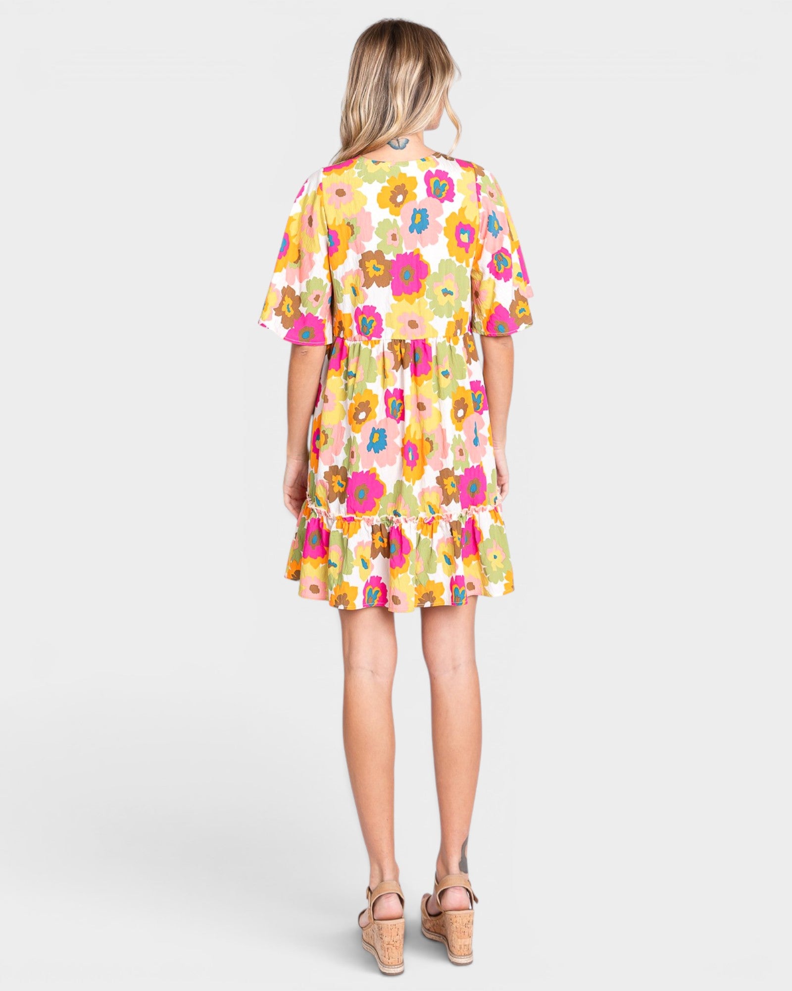 Woman wearing a colorful floral dress on a white background