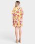 Woman wearing a colorful floral dress on a white background