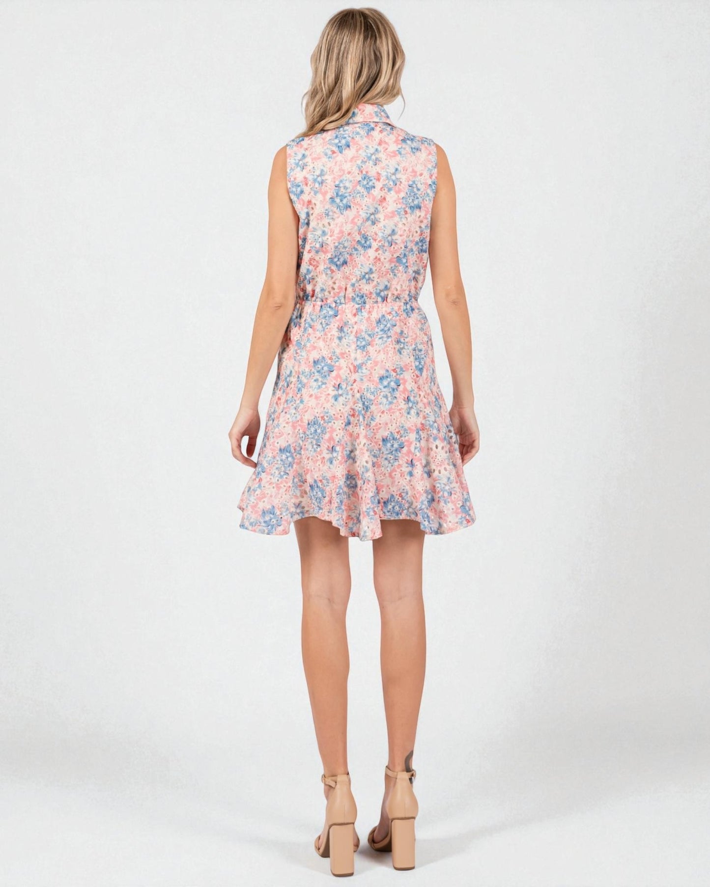 Woman wearing a sleeveless floral dress on a white background