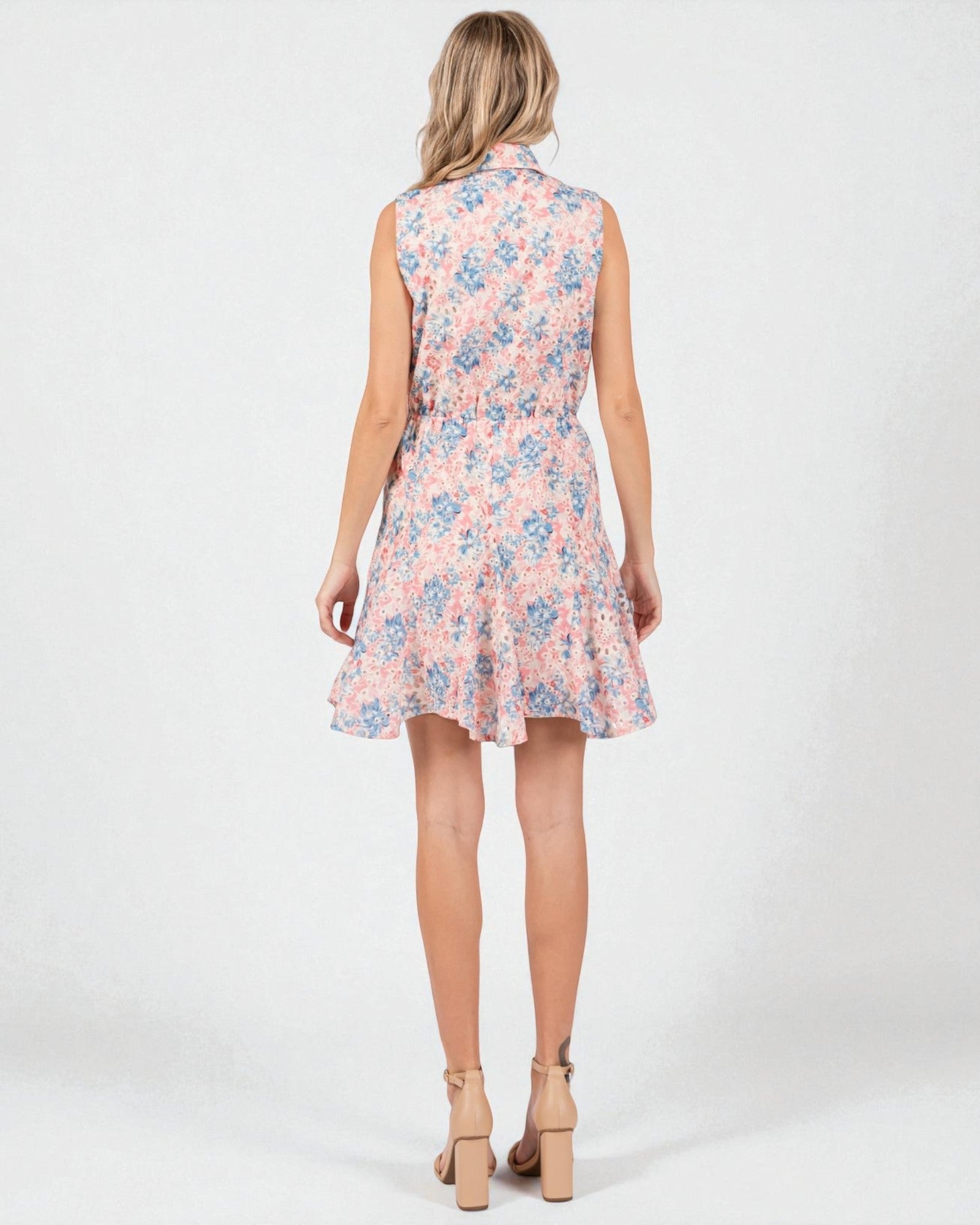 Woman wearing a sleeveless floral dress on a white background