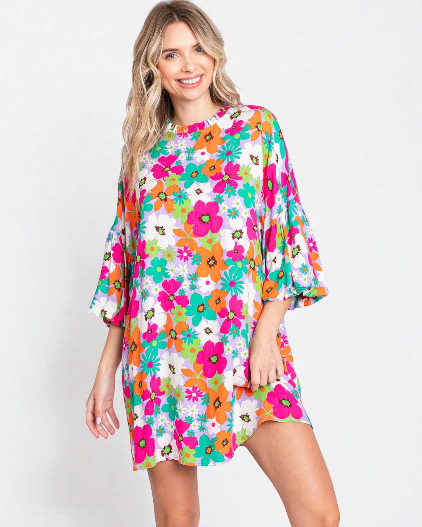 Woman wearing a colorful floral dress on a white background