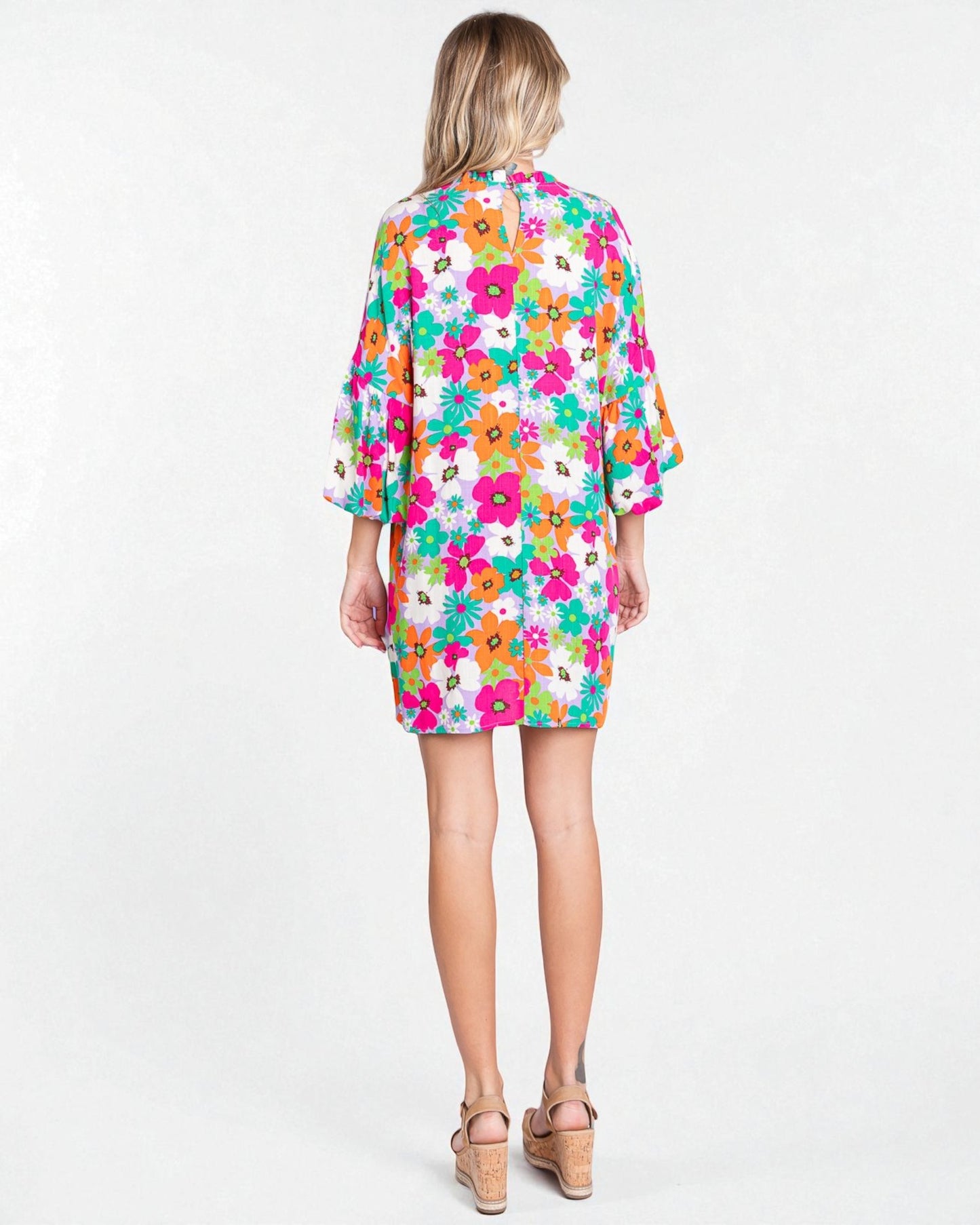 Woman wearing a colorful floral dress on a white background