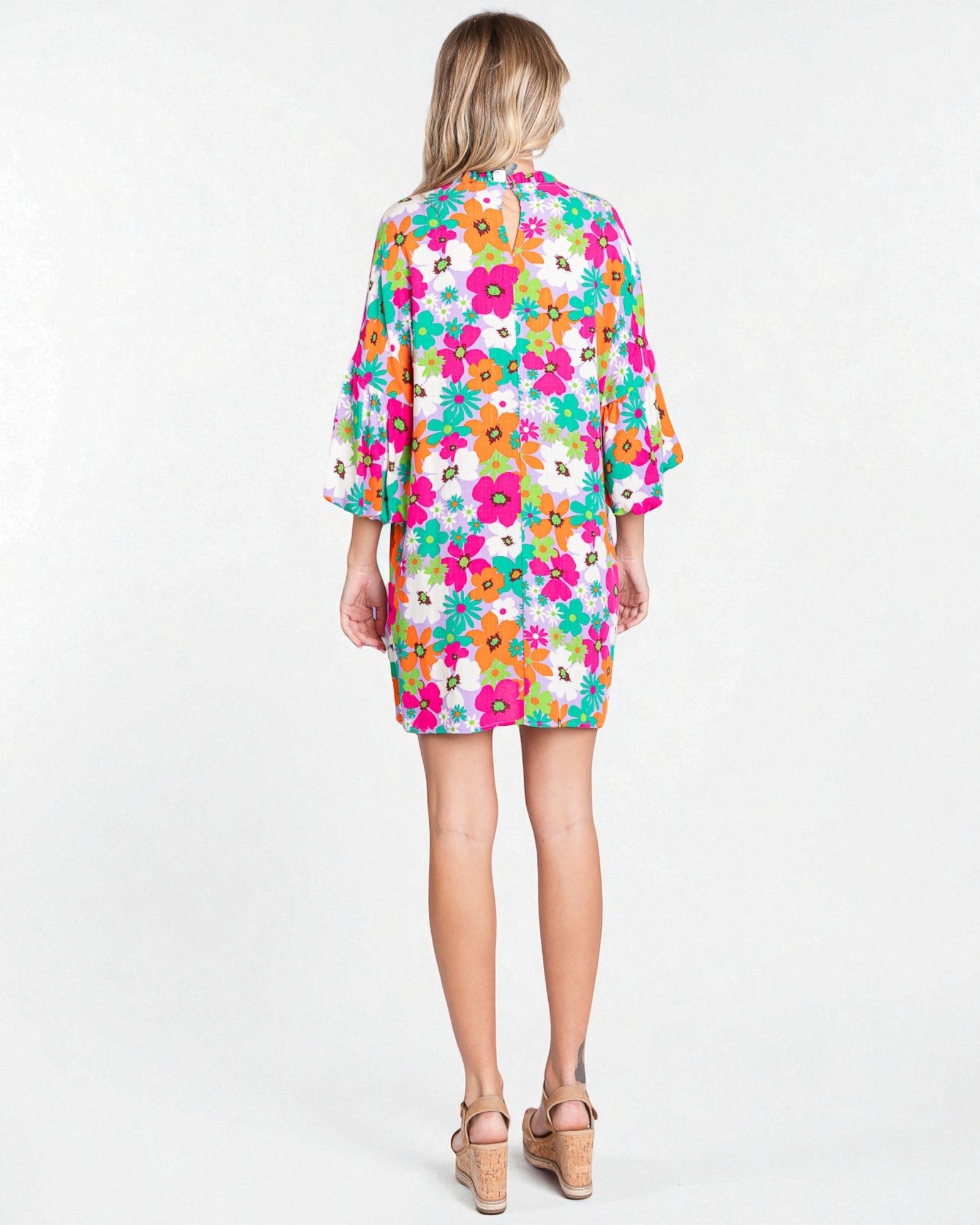Woman wearing a colorful floral dress on a white background