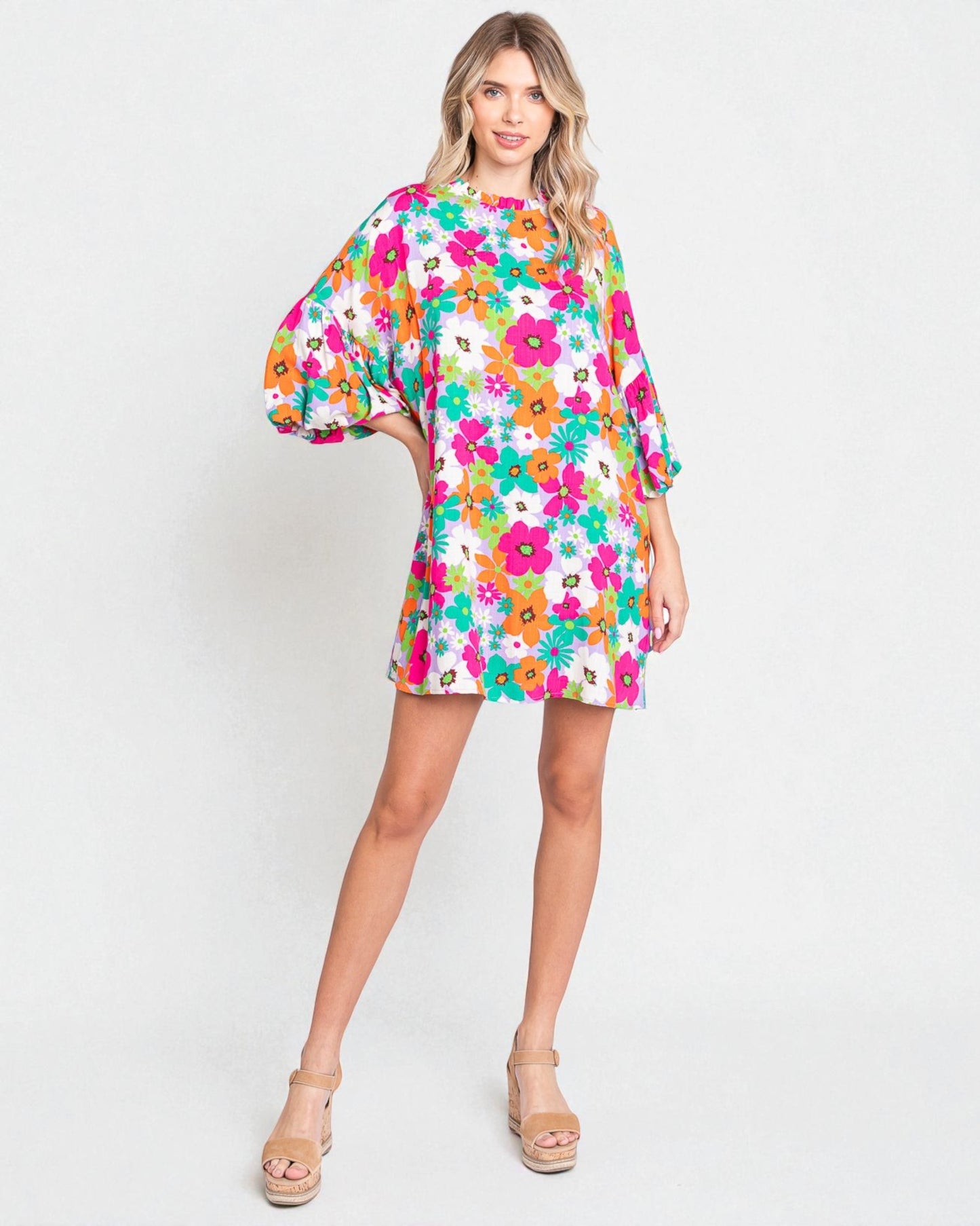 Woman wearing a colorful floral dress on a white background