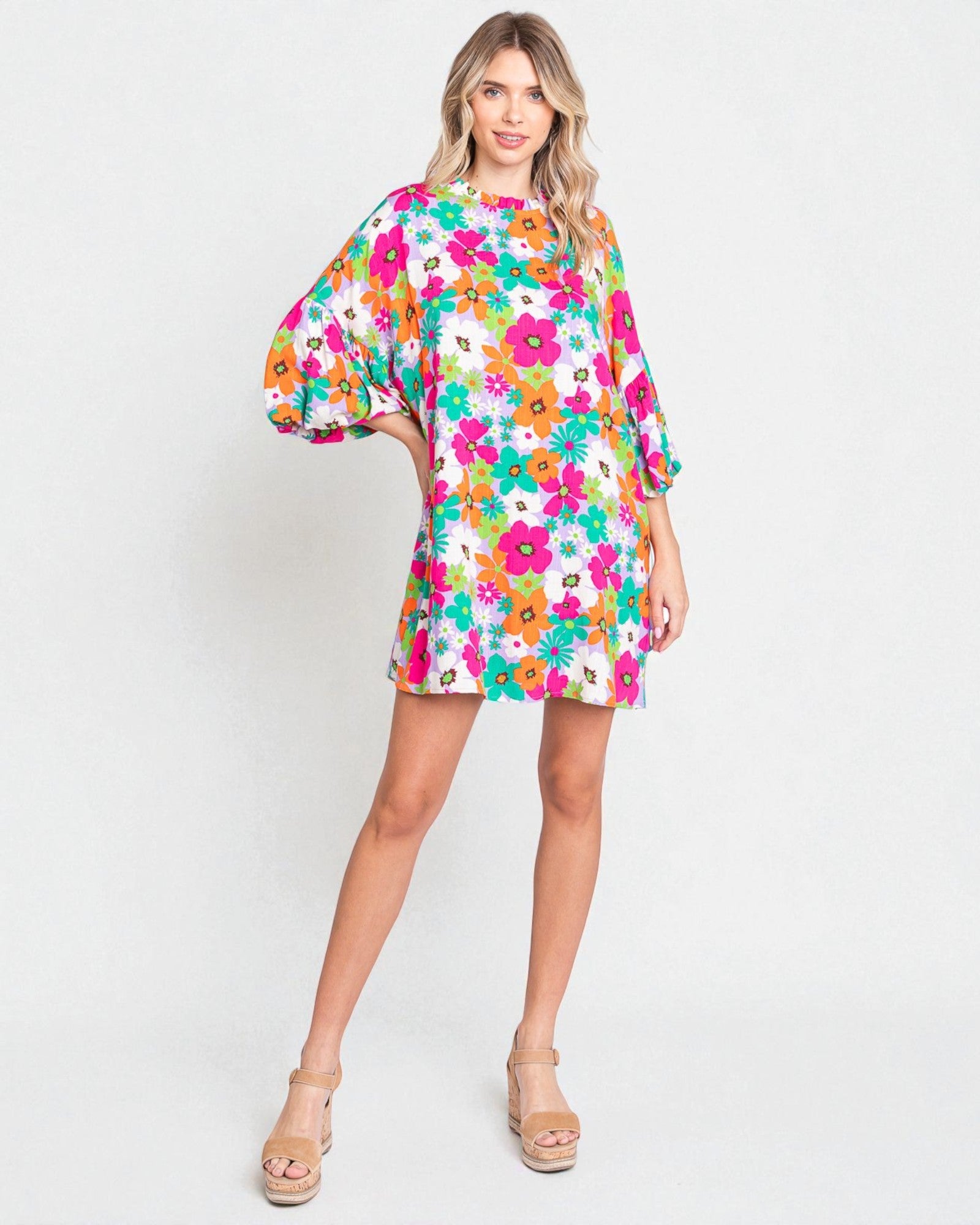 Woman wearing a colorful floral dress on a white background