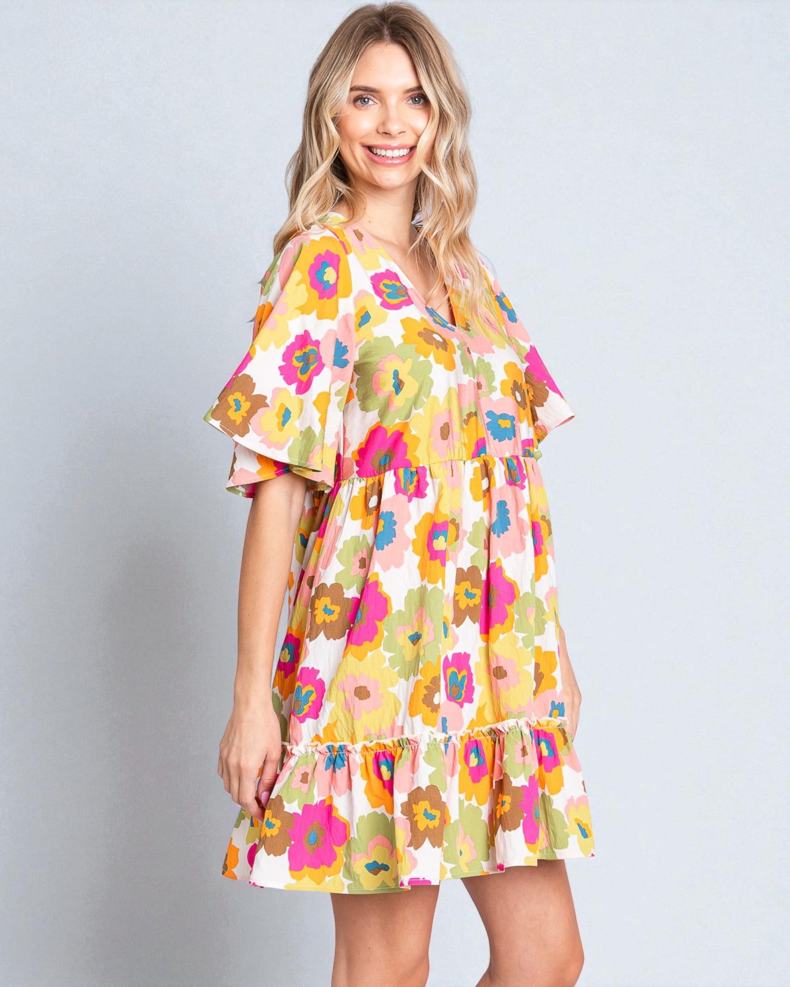 Woman wearing a colorful floral dress on a gray background