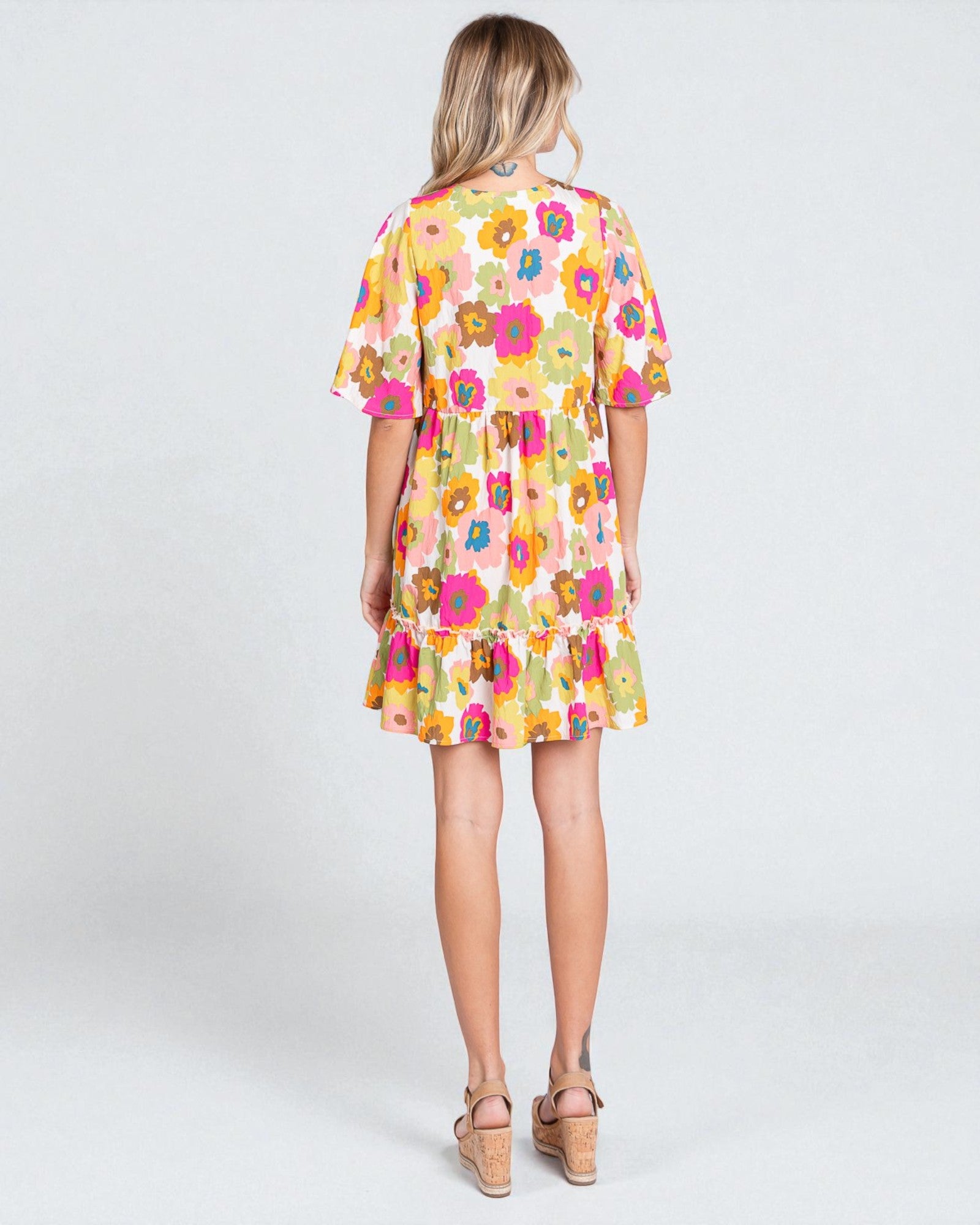 Woman wearing a colorful floral dress on a white background
