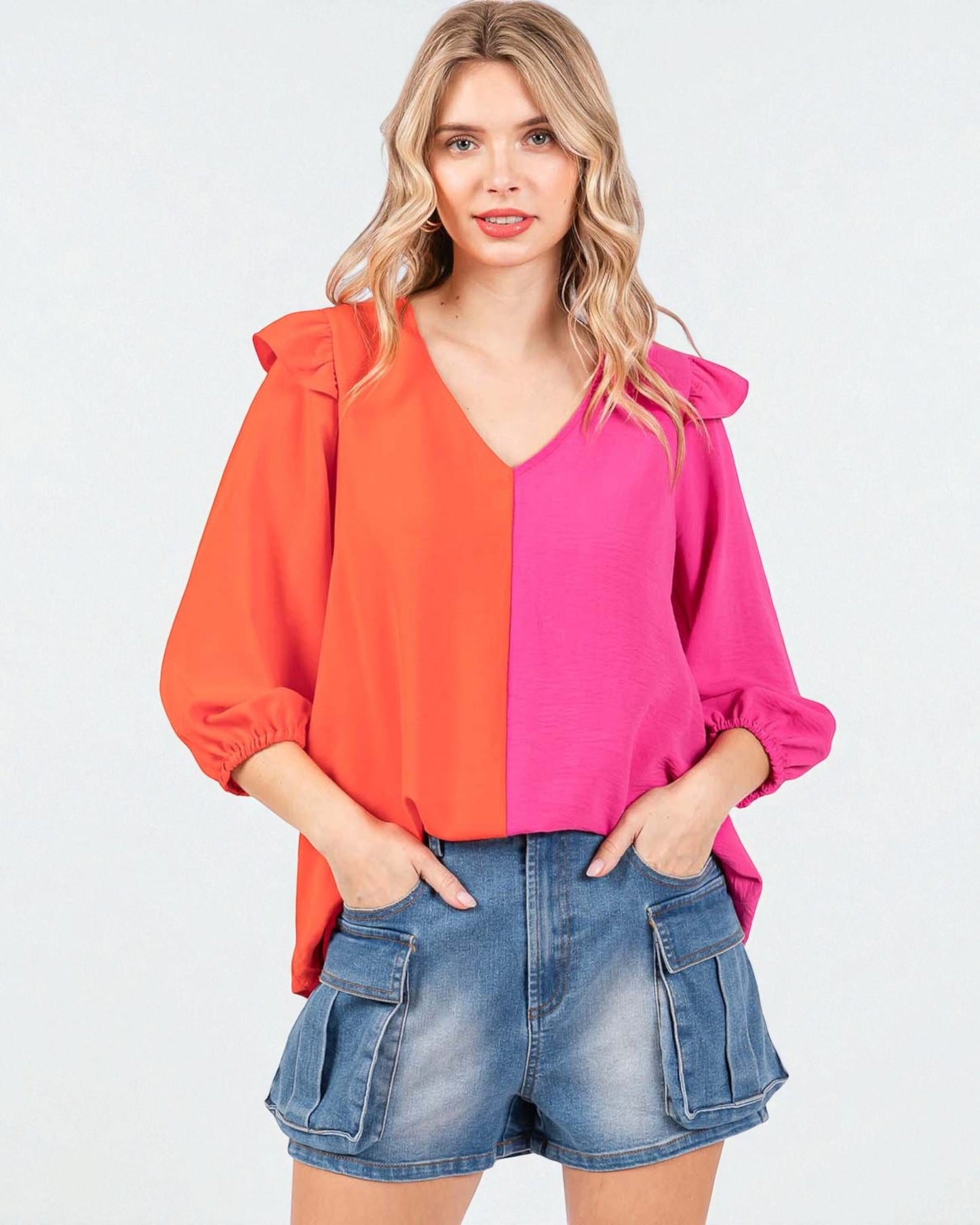 Woman wearing a two-tone blouse with orange and pink colors on a white background