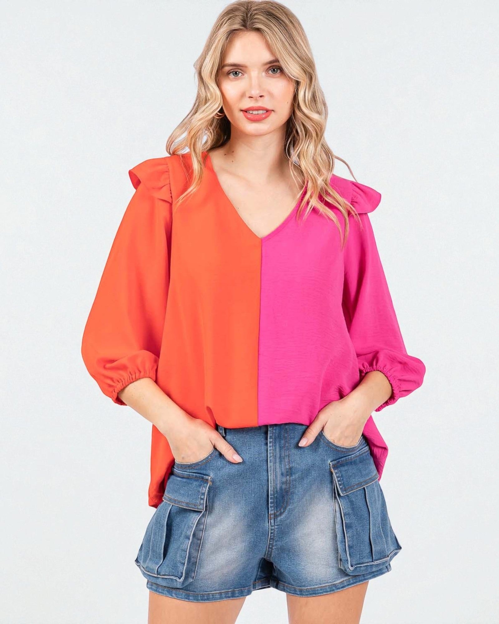 Woman wearing a two-tone blouse with orange and pink colors on a white background