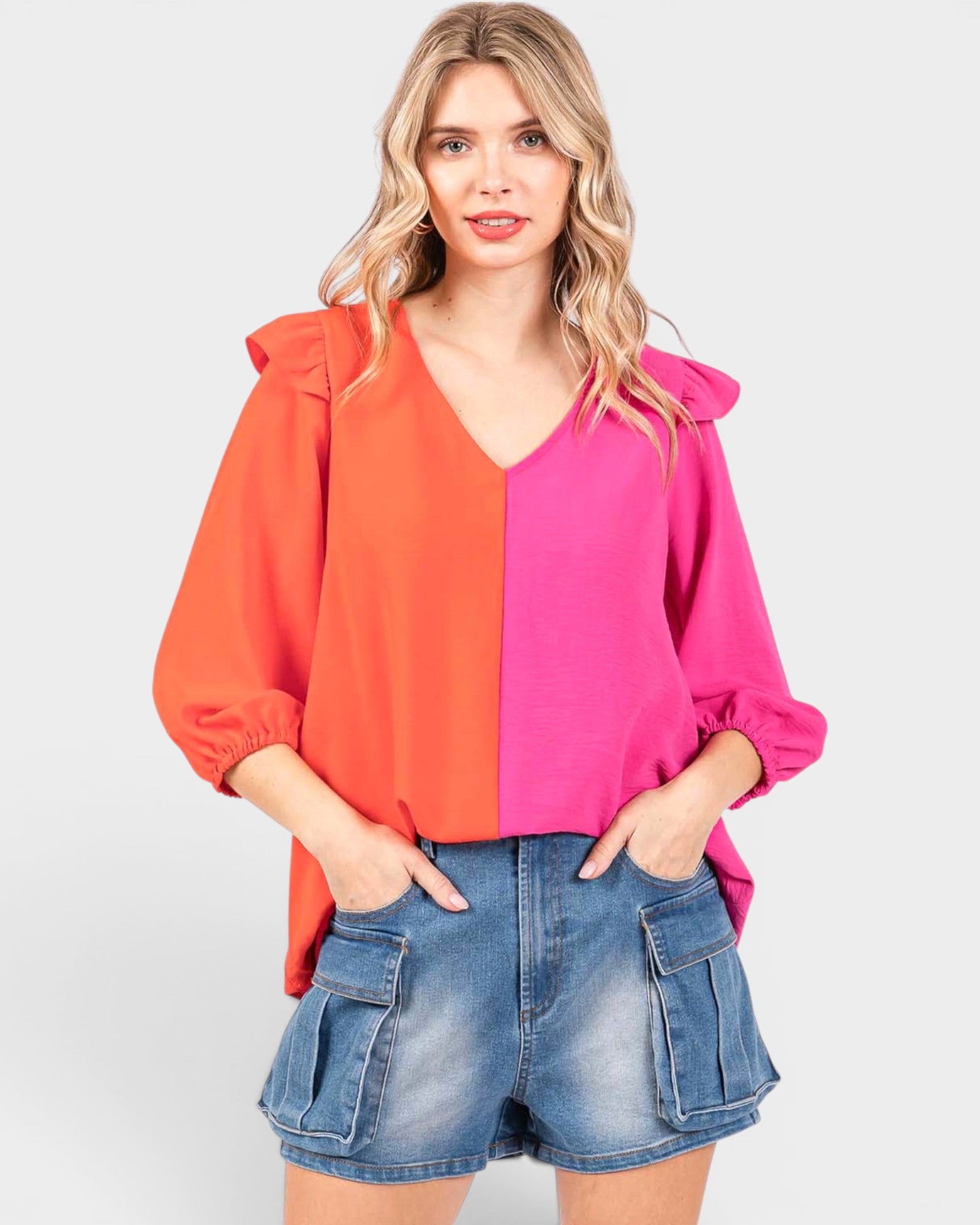 Woman wearing a two-tone blouse with orange and pink on a white background