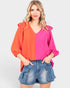 Woman wearing a two-tone blouse with orange and pink on a white background