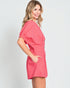 Woman wearing a pink dress on a plain background