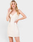 Woman wearing a white lace dress against a plain background