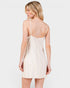 Woman wearing a white lace nightgown on a plain background
