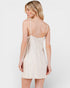 Woman wearing a white lace nightgown against a plain background