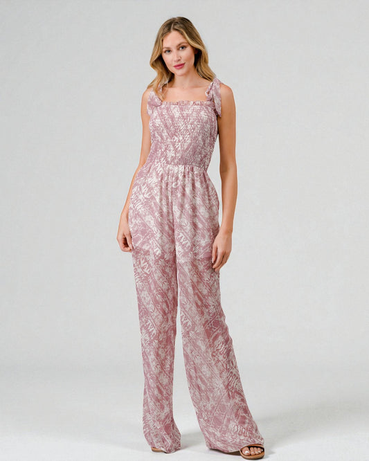 Woman wearing a pink floral jumpsuit on a white background