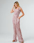 Woman wearing a pink floral jumpsuit on a white background