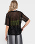 Person wearing a black sheer top with bead details on a white background