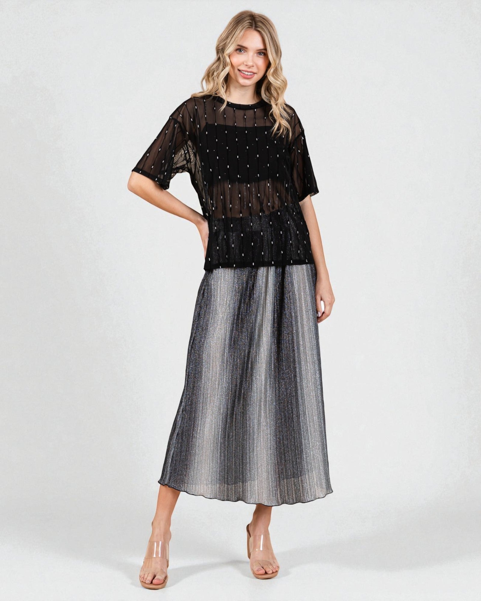 Woman wearing a black and gray dress with sheer overlay on a white background