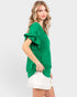Woman wearing a green blouse with ruffled sleeves on a white background