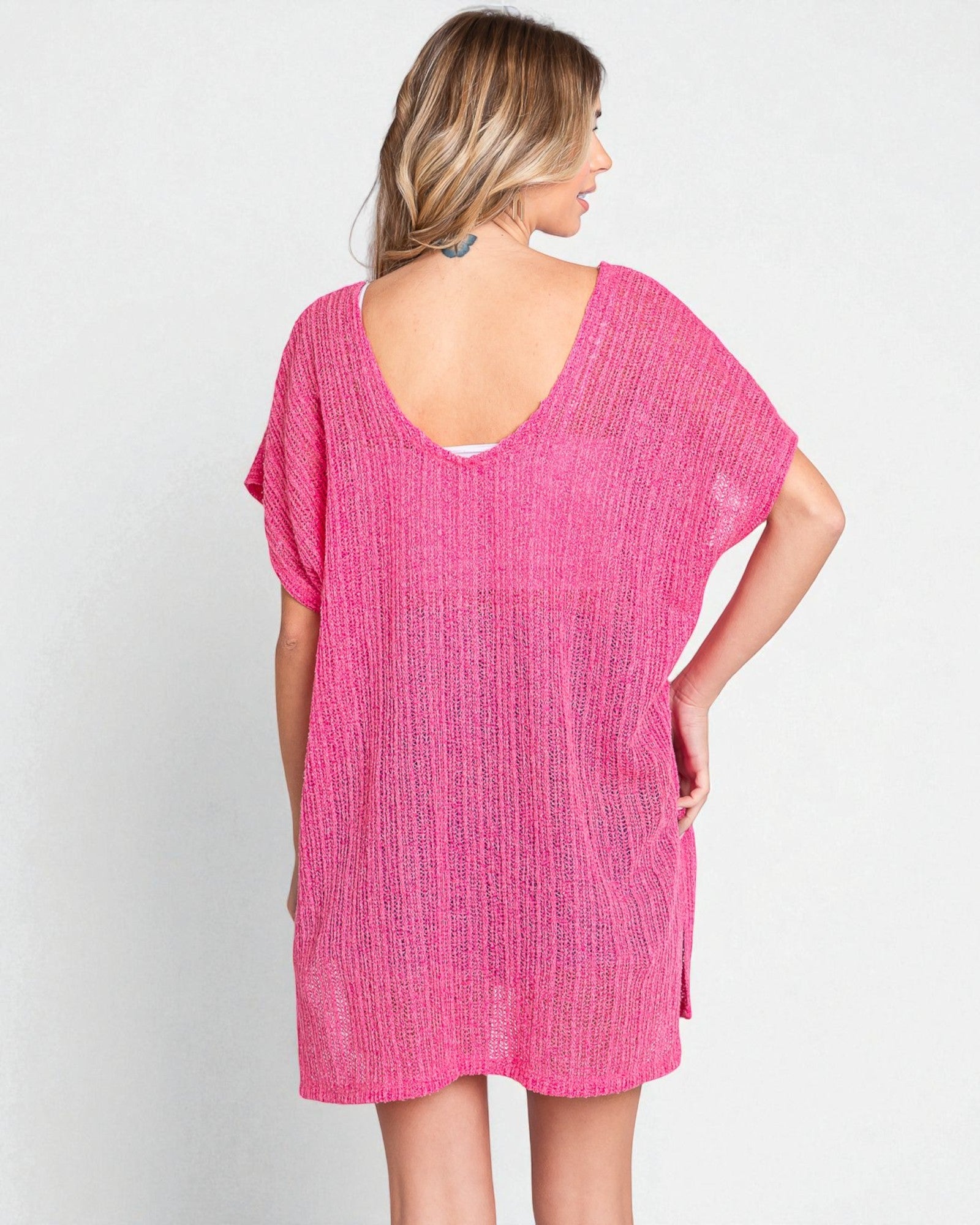 Woman wearing a pink textured dress against a white background