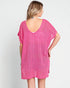 Woman wearing a pink textured dress against a white background