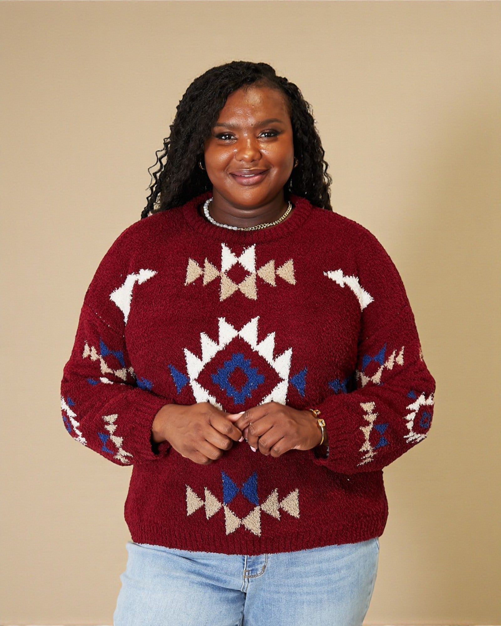 Person wearing a red sweater with geometric patterns on a beige background