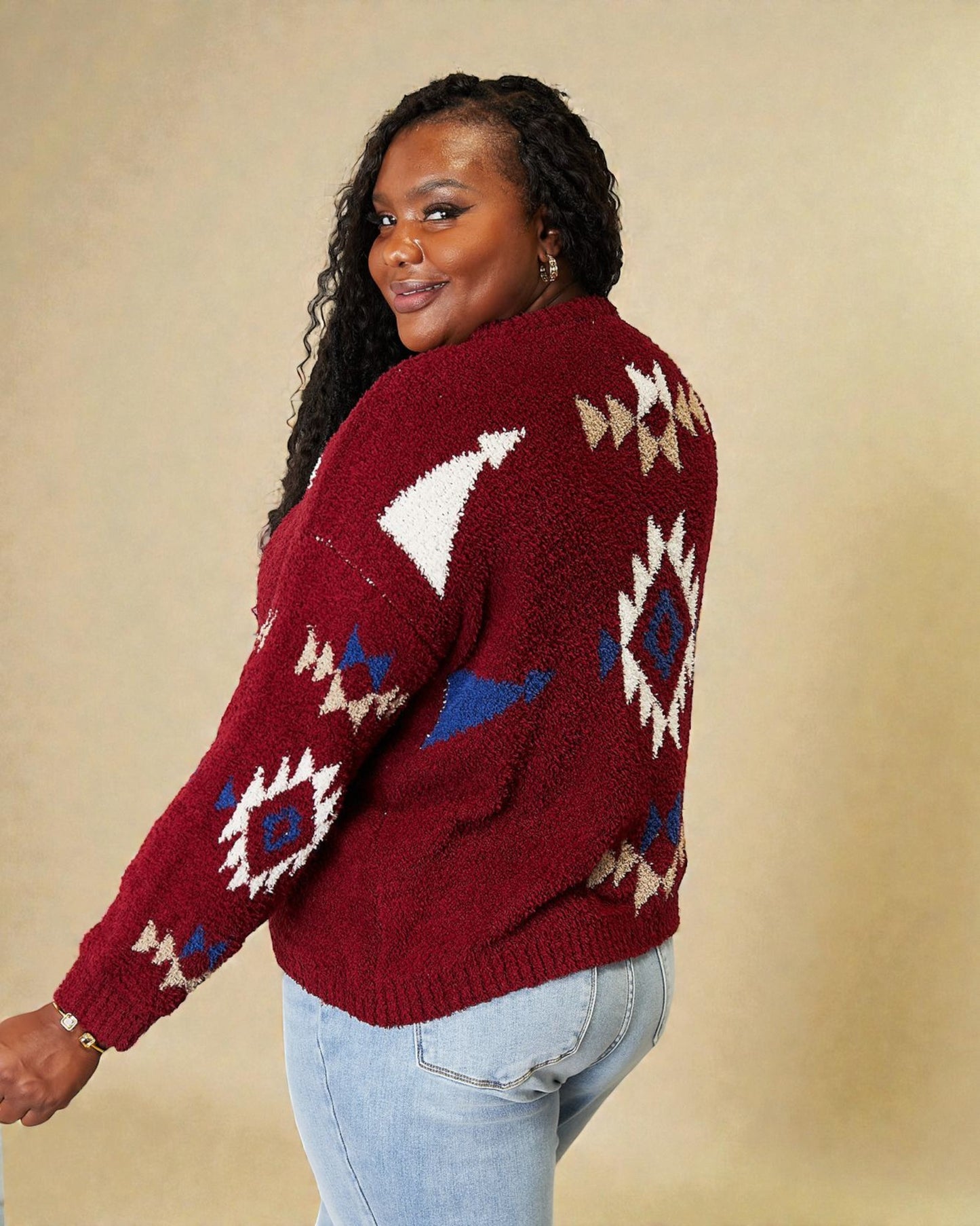 Woman wearing a red sweater with geometric patterns on a beige background