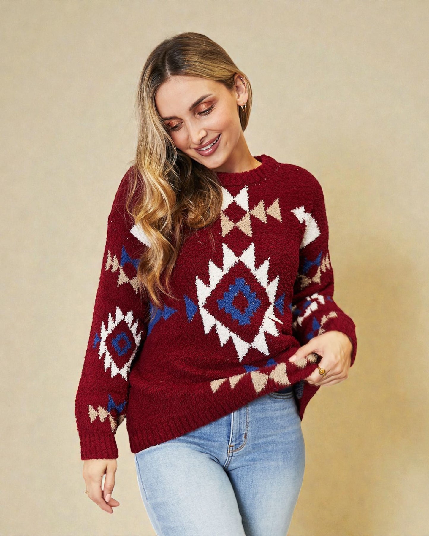 Woman wearing a red sweater with geometric patterns on a beige background