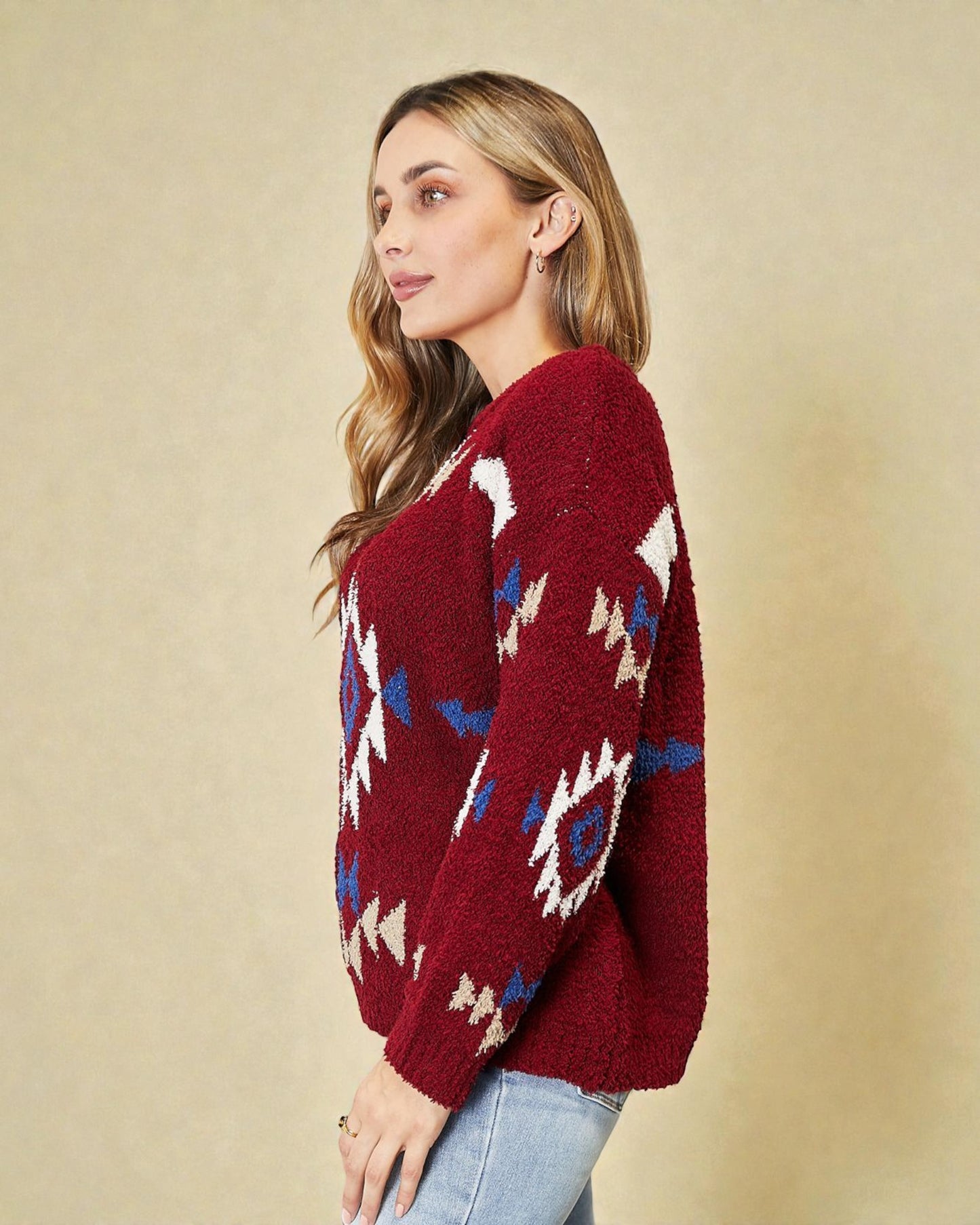 Woman wearing a red sweater with geometric patterns on a beige background