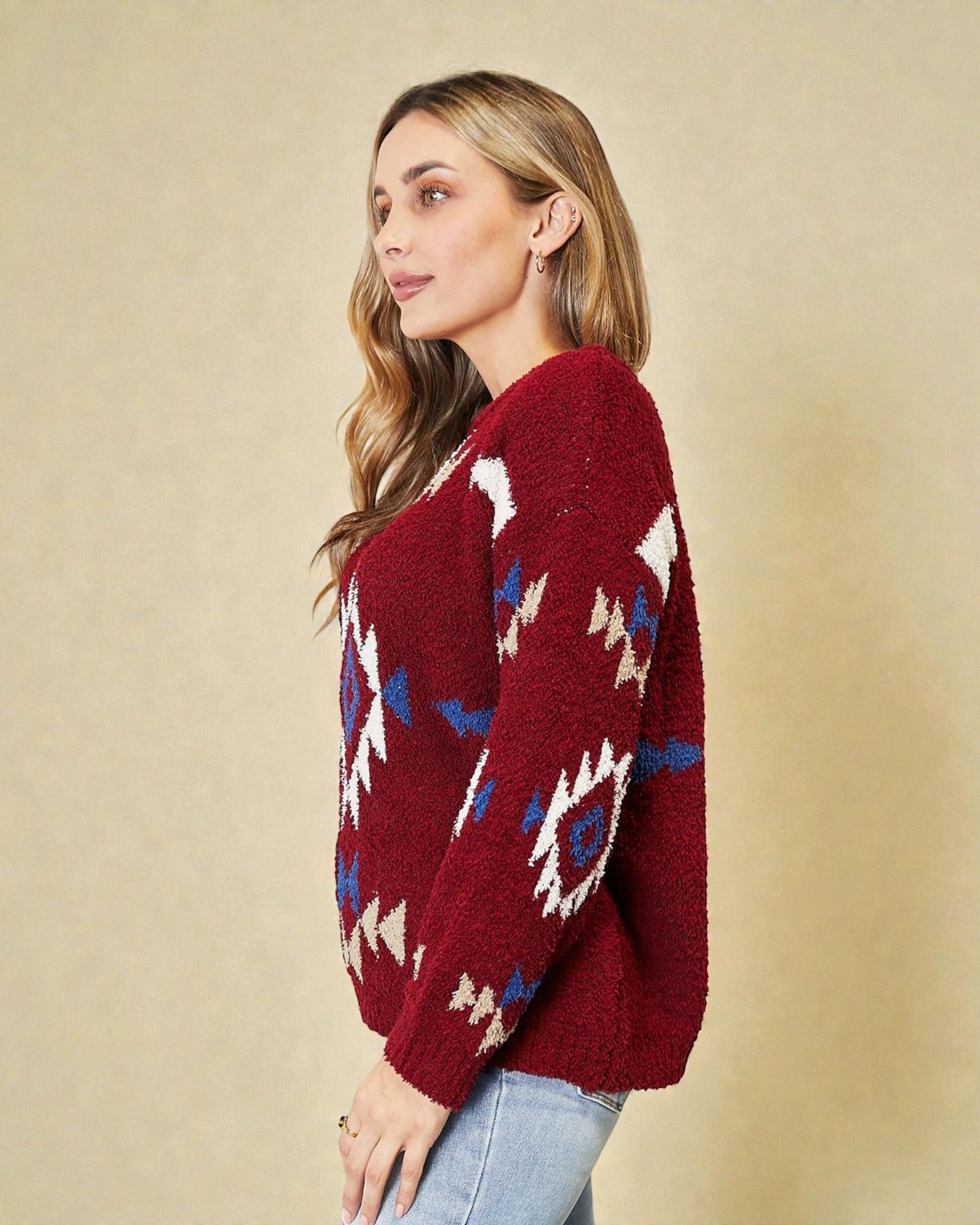Woman wearing a red sweater with geometric patterns on a beige background