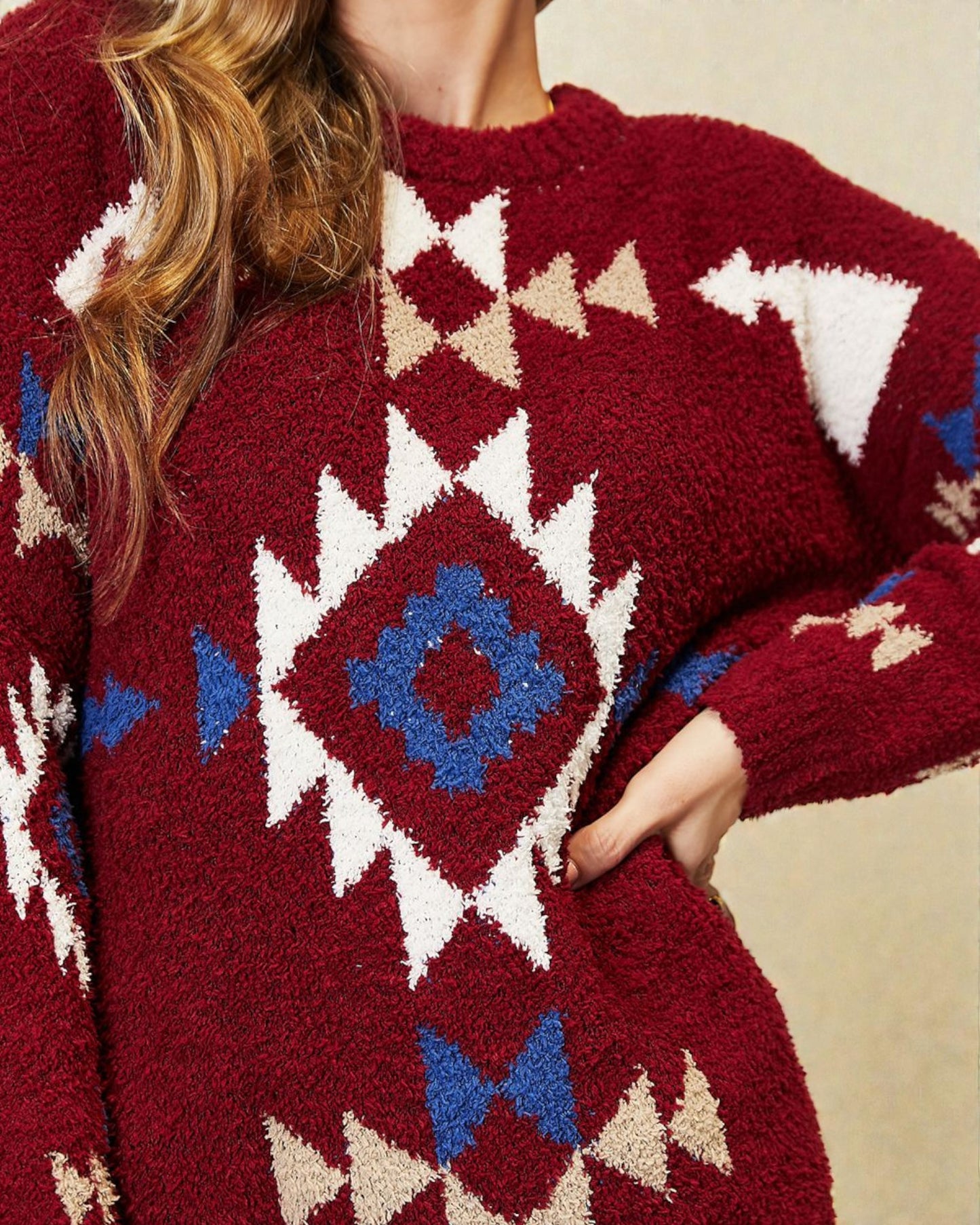 Close-up of a red sweater with geometric pattern on a neutral background
