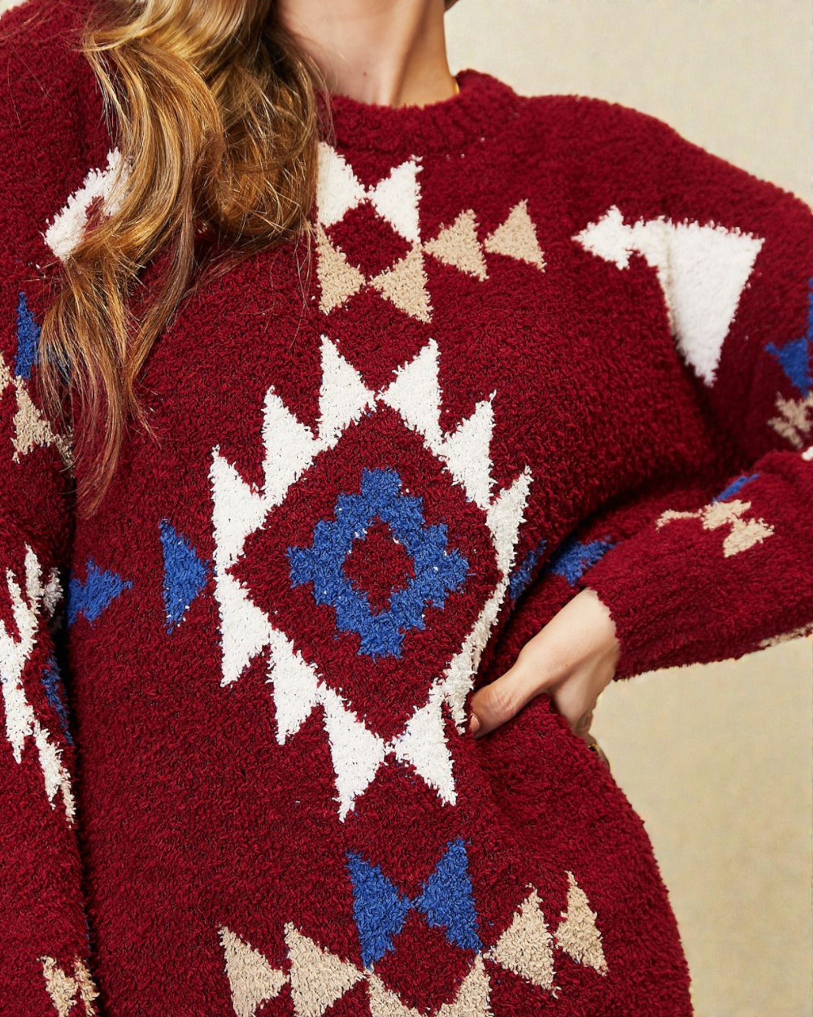 Close-up of a red sweater with geometric pattern on a neutral background
