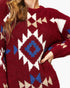 A close-up of a person wearing a fuzzy knit sweater with a Southwestern geometric pattern in burgundy, cream, and blue.