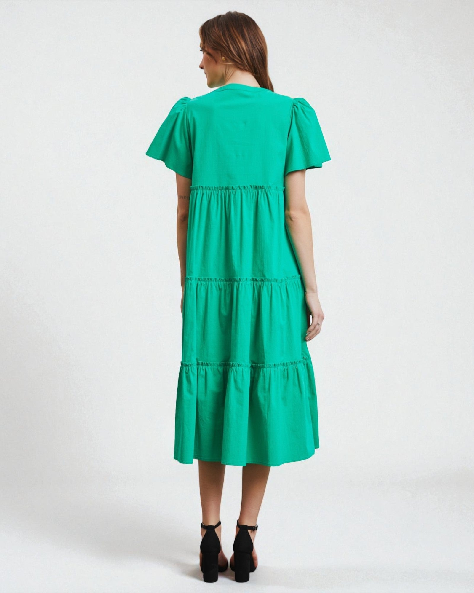 Green dress worn by a person on a white background